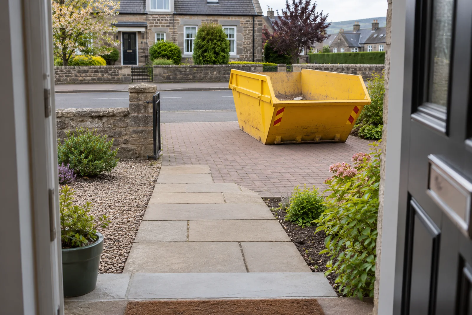 Yellow skip positioned with a clear route between house and road